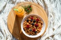 Top horizontal view on healthy breakfast granola berries in white bowl and fresh orange juce on round wooden desk on cozy knitted Royalty Free Stock Photo