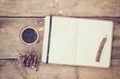 Top image of open notebook with blank pages, next to pine cones and cup of coffee over wooden table. top image, glitter overly Royalty Free Stock Photo