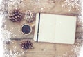 Top image of open notebook with blank pages, next to pine cones and cup of coffee over wooden table. top image, glitter overly wit Royalty Free Stock Photo