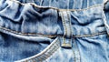 Top of jeans. Fragment of a belt, pocket and strap. Rough denim fabric and coarse seams with thick threads Royalty Free Stock Photo