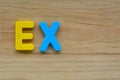 Top lay of the word Ex on a wooden background.