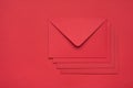 Top layout flatlay close up view photo of heap pile stack of four envelopes isolated red backdrop with empty space
