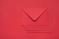 Top layout flatlay close up view photo of heap pile stack of four envelopes isolated red backdrop with empty space Royalty Free Stock Photo