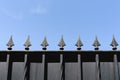 Top of a metal fence with spikes and blue sky Royalty Free Stock Photo