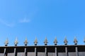 Top of a metal fence with spikes and blue sky Royalty Free Stock Photo