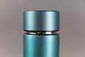 Top of modern thermos opposite gray background. Cylindrical vacuole flask in turquoise color. Container for hot and cold drinks.