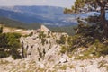 At the top of mount AI-Petri, the cable car building, pine and a scattering of stones in the foreground