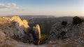 View through a gorge on Mount Ardal into the vast landscape at sunset. Royalty Free Stock Photo