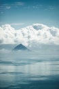 The top of the mountain between water and clouds.