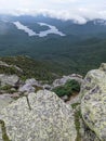 On top of mountain with views of lakes and trees and clouds