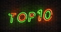 Top 10 neon light green and red text on empty red brick wall banner. Bright sign of top ten list winners at night. Design template Royalty Free Stock Photo