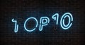 Top 10 neon light text with burnt out lamps on empty red brick wall banner. Bright neon sign of top ten list winners at night. Des