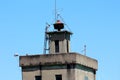 Top of old dilapidated fire station tower with large vintage retro siren and metal ladder mounted on one side