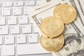 Top overhead above close up view photo of pile of golden bitcoin laying on american paper banknotes with white keyboard buttons on