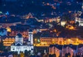 Top panoramic view of illuminated orthodox church and old buildings in downtown of Sighisoara, Romania at night