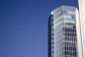 Top part of a blue modern corporate high-rise building with a striped design.