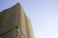 Side view of the top part of a modern corporate building with yellowish overhangs in each floor. Royalty Free Stock Photo