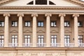 Top part of a newly restored old beige building with columns