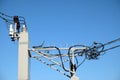 Top part of rural power supply transformer with high voltage wires power line over clear cloudless blue sky