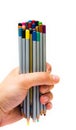 Top of the pencil. The male hand holds a bunch, a bunch, a bunch of multi-colored pencils on a white background. Very full