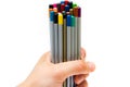 Top of the pencil. The male hand holds a bunch, a bunch, a bunch of multi-colored pencils on a white background. Only the top of