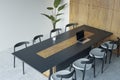 Top perspective view on stylish black and wooden decorated conference table with modern laptop and chairs around on concrete floor Royalty Free Stock Photo