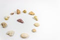 Top perspective wide shot of several circular positioned colorful stones that collected from beach on white background Royalty Free Stock Photo