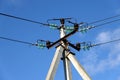 The top of a power line pole with wires and insulators against a blue sky with clouds Royalty Free Stock Photo