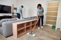 Top quality janitorial team. Two professional cleaners working together in the living room. Young afro american woman Royalty Free Stock Photo