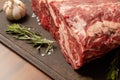 Top quality marbled beef. A piece lies on a cutting board with rosemary and garlic