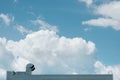 Top of the roof of a production metal building against a blue sky with clouds. Royalty Free Stock Photo