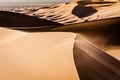 Top of a sand dune with sand being blown over by the wind. Desert landscape. Erg Chebbi, Morocco