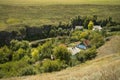 Top scenic view Eastern European village houses in green canyon surrounded by field spring time clear weather country side