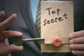 Top secret concept. Top secret documents or message and a decryption key in businessman hands.