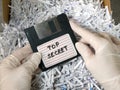 Top secret information on retro vintage floppy disk magnetic computer among shredder paper, thief information concept