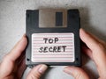 Top secret information on retro vintage floppy disk magnetic computer among shredder paper, thief information concept