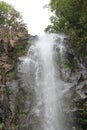 The top section of Wailua Falls plummeting down a rocky cliff surrounded by lush vegetation in Hana, Maui Royalty Free Stock Photo