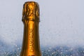 Top of shining Champagne bottle with rain drop on window