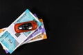 Top shot of a car on money notes placed over black background. Royalty Free Stock Photo