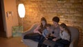 Top shot of caucasian mother and three daughters watching into tablet with attentiveness and interest in cosy home