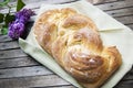 Top shot, close up of fresh baked homemade vegan braided loaf on a wooden, rustic table background, home baking, minimal Easter