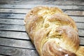 Top shot, close up of fresh baked homemade vegan braided loaf on a wooden, rustic table background, home baking, minimal Easter