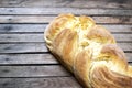 Top shot, close up of fresh baked homemade vegan braided loaf on a wooden, rustic table background, home baking, minimal Easter