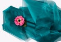 Top shot of a pink poppy on a turquoise creased silky wavy cloth