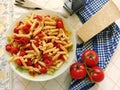 Top shot of a plate full of Italian pasta with sliced cherry tomatoes and spices