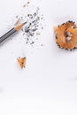 Top shot of a sharpened pencil with waste shavings and broken graphite over white paper Royalty Free Stock Photo