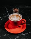 Top Side of Parallel A Red Mug Filled With Espresso With Topping Detail and A Small Glass Cup Of Coffee Beans In The Back. Royalty Free Stock Photo