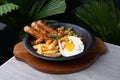 Top Side View Of A Gourmet Filled With Sausages, French Fries, Fried Eggs. On A White Table Royalty Free Stock Photo