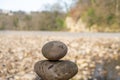 The top of a stack of balancing stones with a rocky beach in the background