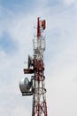Top of strong tall cell phone red and white antenna tower with multiple antennas and transmitters